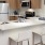 Spacious and well lit kitchen with wood floors and stainless steel appliances. 