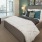 Spacious and well lit bedroom with plush carpet and large windows